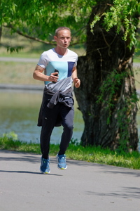 Young man running on a park alley